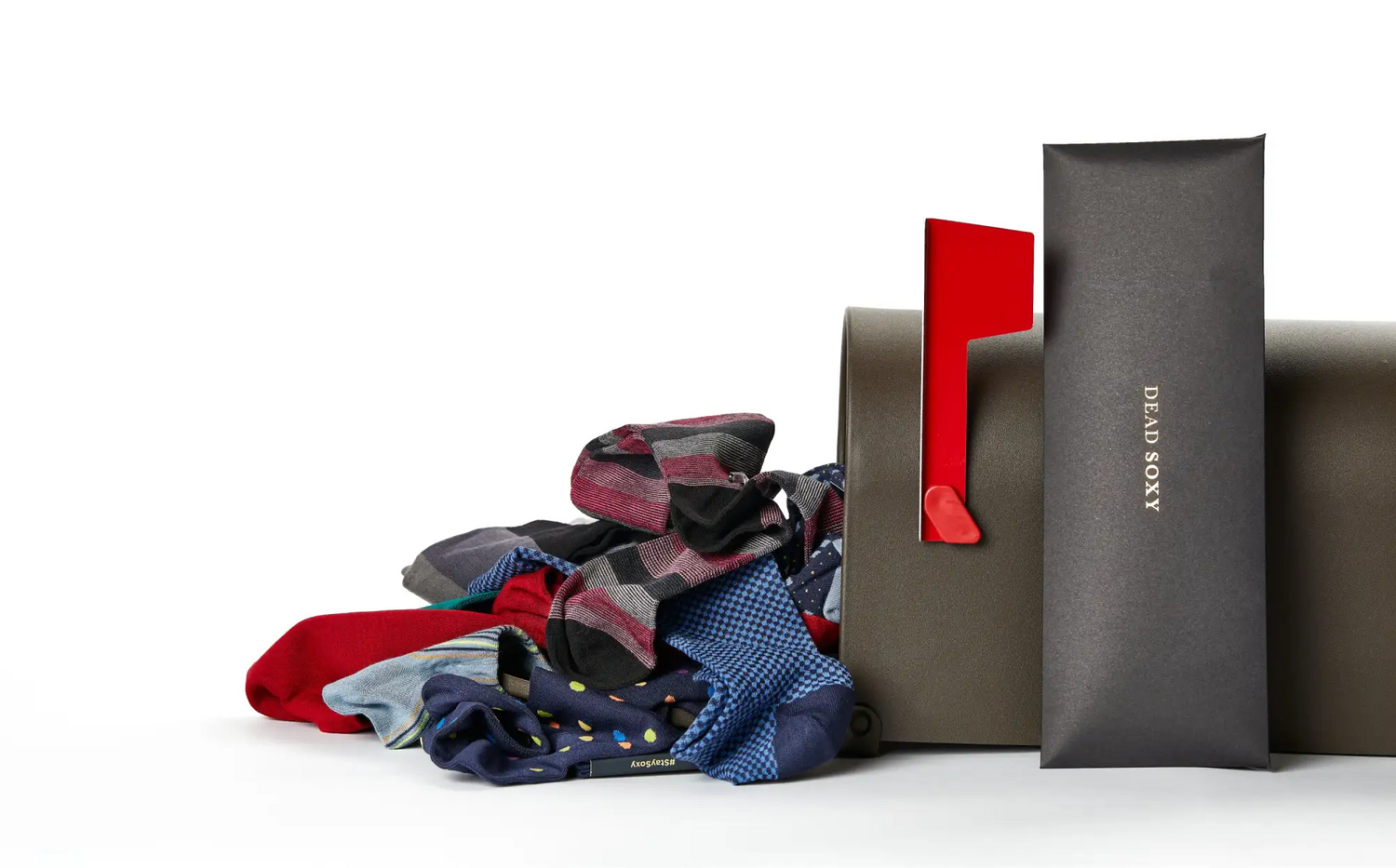A selection of colorful DeadSoxy socks beside their gift boxes
