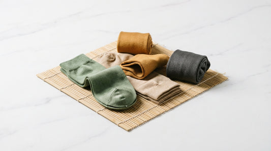 Bamboo fiber socks in earth tones displayed on a natural bamboo mat showing silky fabric texture