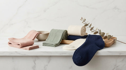 Womens sock collection in feminine colors arranged artfully on a marble vanity surface