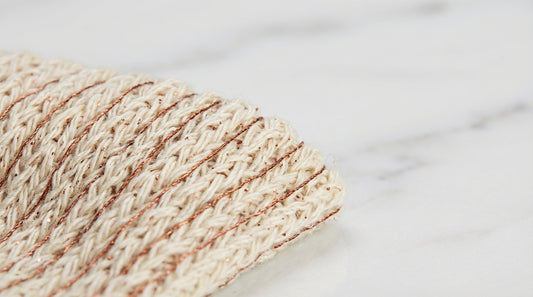 Close-up of copper-infused sock fibers showing woven copper oxide threads alongside natural yarn on a laboratory testing surface