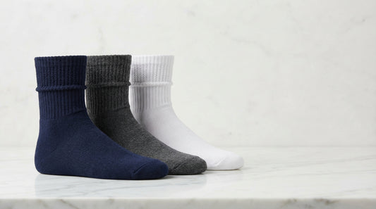 Three pairs of premium crew socks in navy charcoal and white showing mid-calf height and ribbed cuff detail