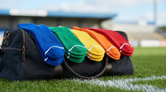Youth team socks in bright colors stacked in a sports equipment bag on a field sideline