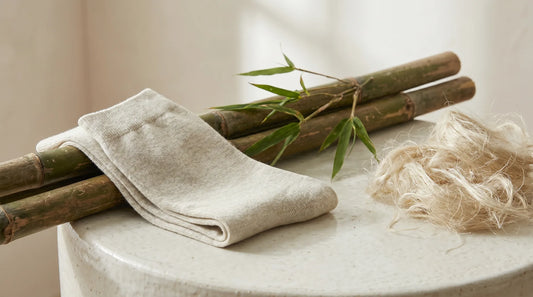 Pale bamboo-viscose socks beside raw bamboo stalks and natural fibers