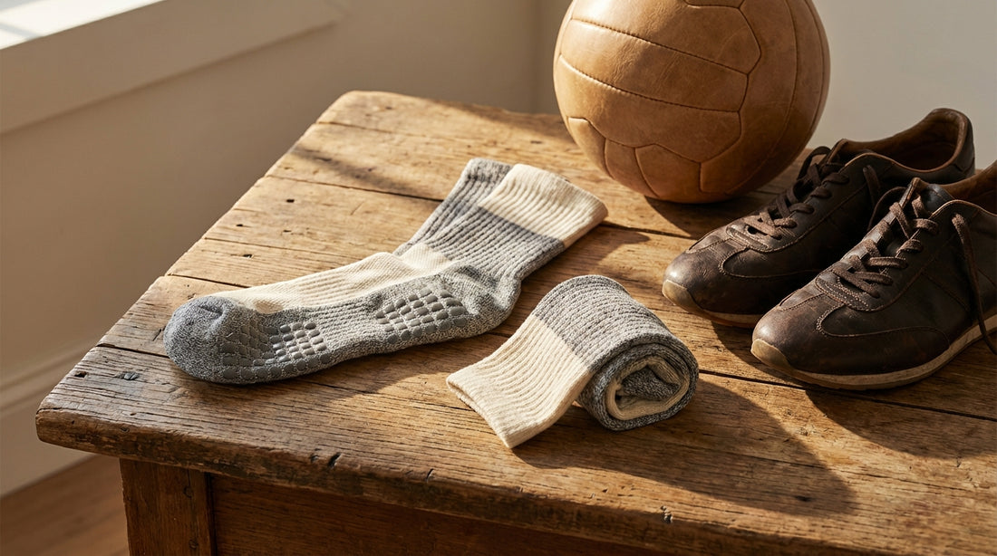 Premium grip socks displayed on a wooden surface showing silicone grip pads alongside athletic shoes and a soccer ball in natural light