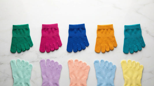 Five-toe socks in bright colors showing individual toe pockets on a white surface