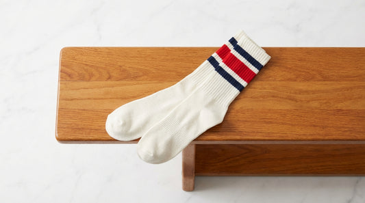 Retro athletic tube socks with classic stripe bands laid flat on a gym bench
