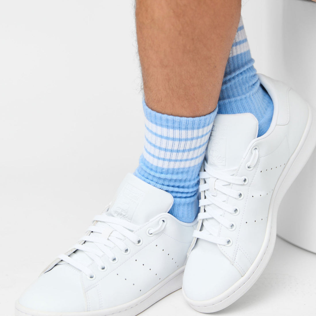 powder blue crew socks with 4 white stripes on leg in white sneaker