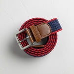 Navy and red stretch-woven belt with leather accents and metal buckle shown in close-up and lifestyle model photos.
