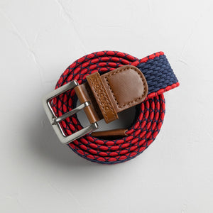 Navy and red stretch-woven belt with leather accents and metal buckle shown in close-up and lifestyle model photos.
