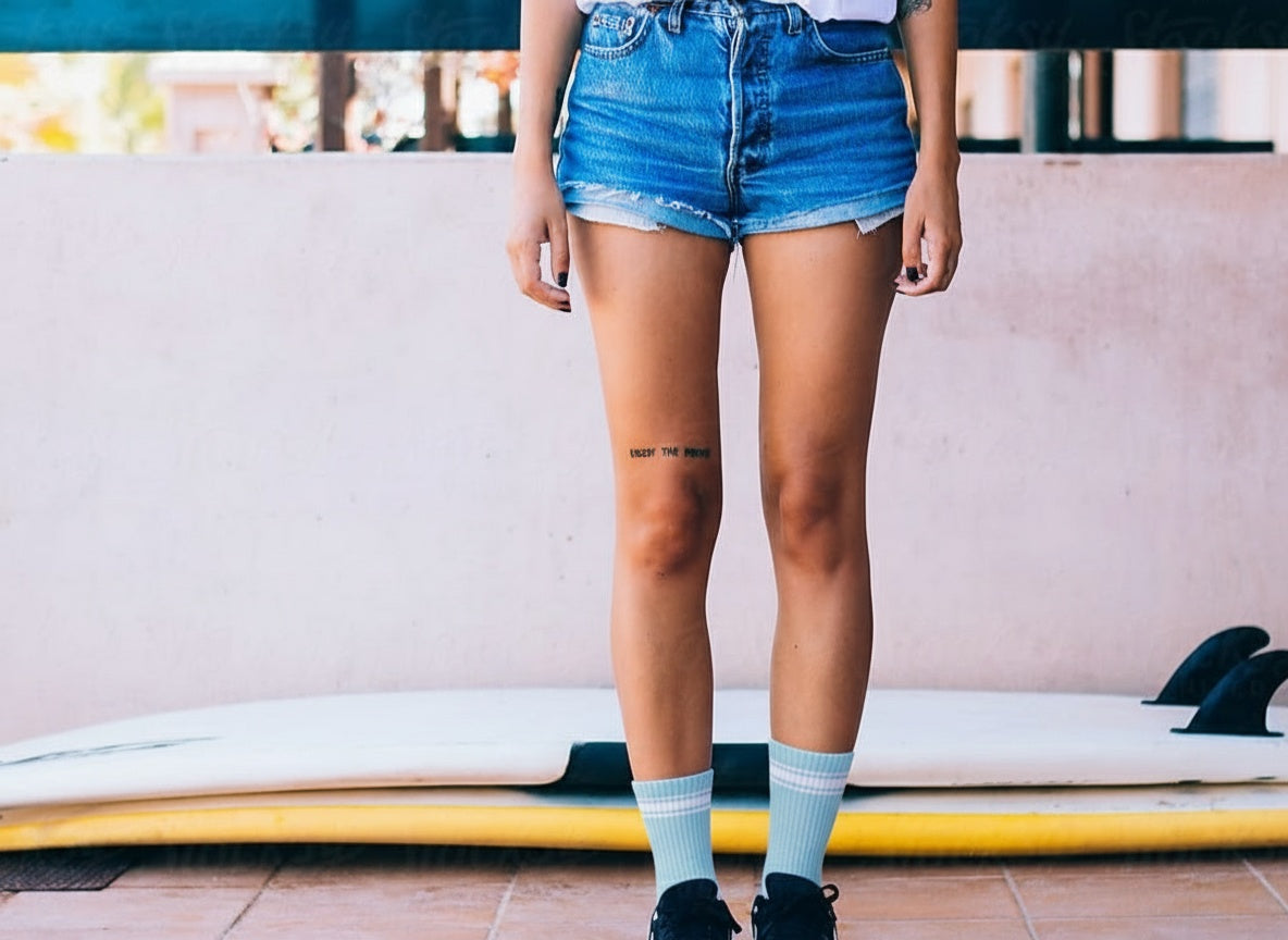 Blue quarter crew sock worn with surfboard backdrop