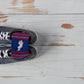 shot of the detail in the stitch on 8-bit archie red and navy stripe socks inside a grey sneaker