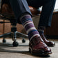 DeadSoxy Smith cotton dress socks styled with dress shoes in a seated business setting