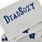 Close-up of DeadSoxy logo on light-grey TrueStay‚Ñ¢ cuff with silicone grip dots on Drew floral sock.