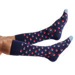 1 dark blue dress sock with circles half red and the other half light blue shown on legs coming into the image from the left