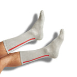 Silver athletic casual socks with cushion foot and white, red, and black stripes down the back of the leg shown on legs