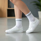 White and grey quarter crew socks styled with white sneakers in a casual lifestyle setting.