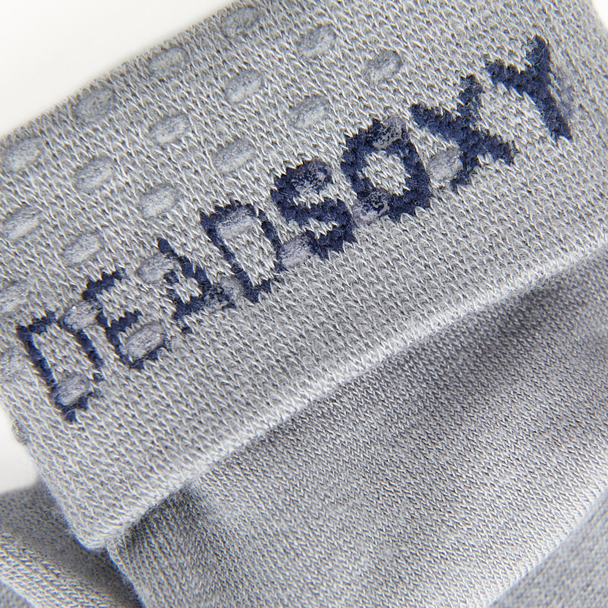 Close up shot of grey sock welt featuring clear silicone dots