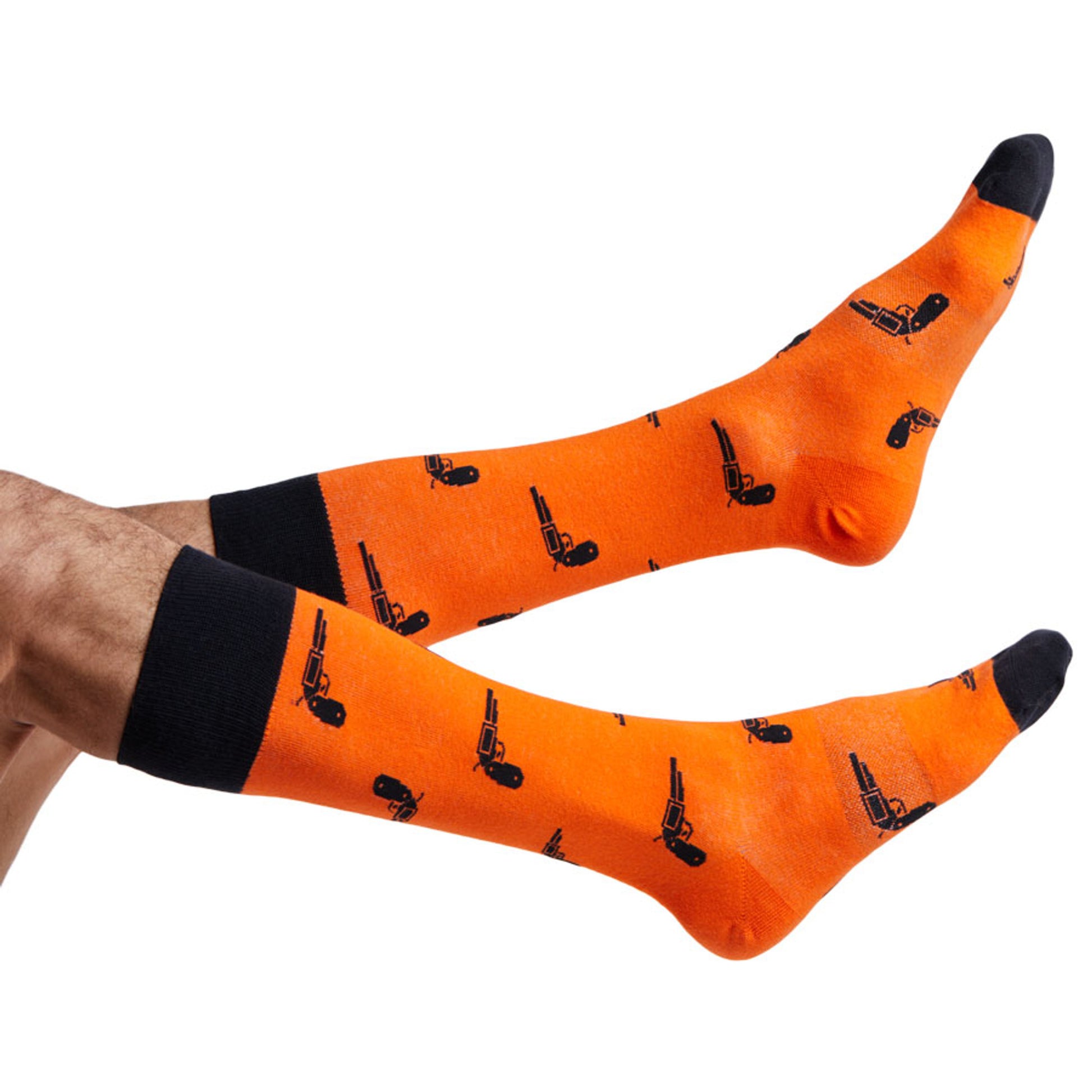 Orange and black Oklahoma dress socks with pistols on them displayed on feet coming into the image from the left.