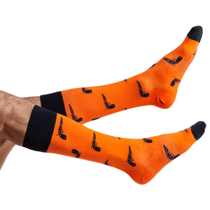 Orange and black Oklahoma dress socks with pistols on them displayed on feet coming into the image from the left.