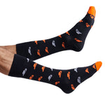 Orange and black Oklahoma dress socks with cowboy hats shown on feet coming into the image from the left.