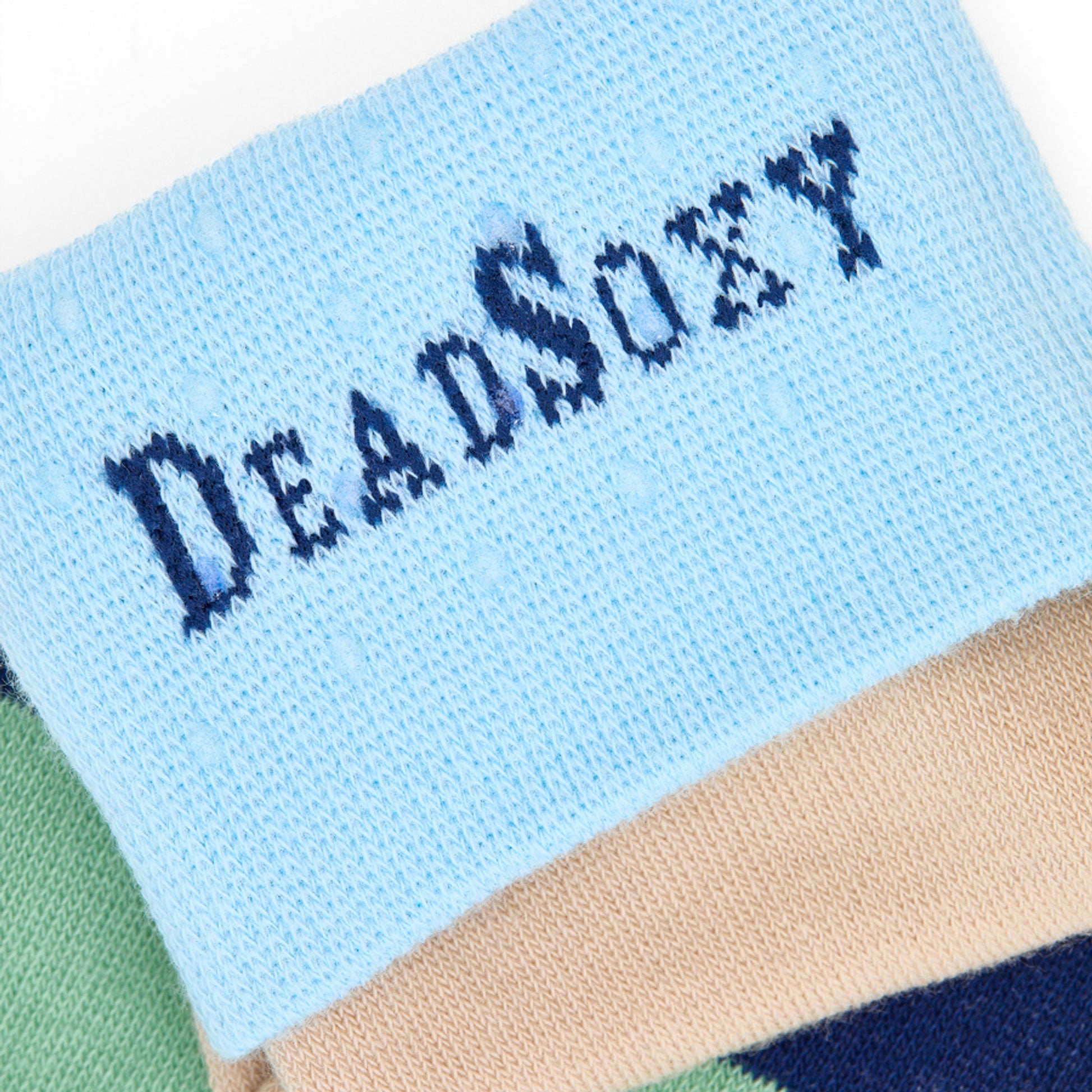 Close-up of DeadSoxy logo woven into light-blue TrueStay‚Ñ¢ cuff on Jerome striped men‚Äôs dress sock.