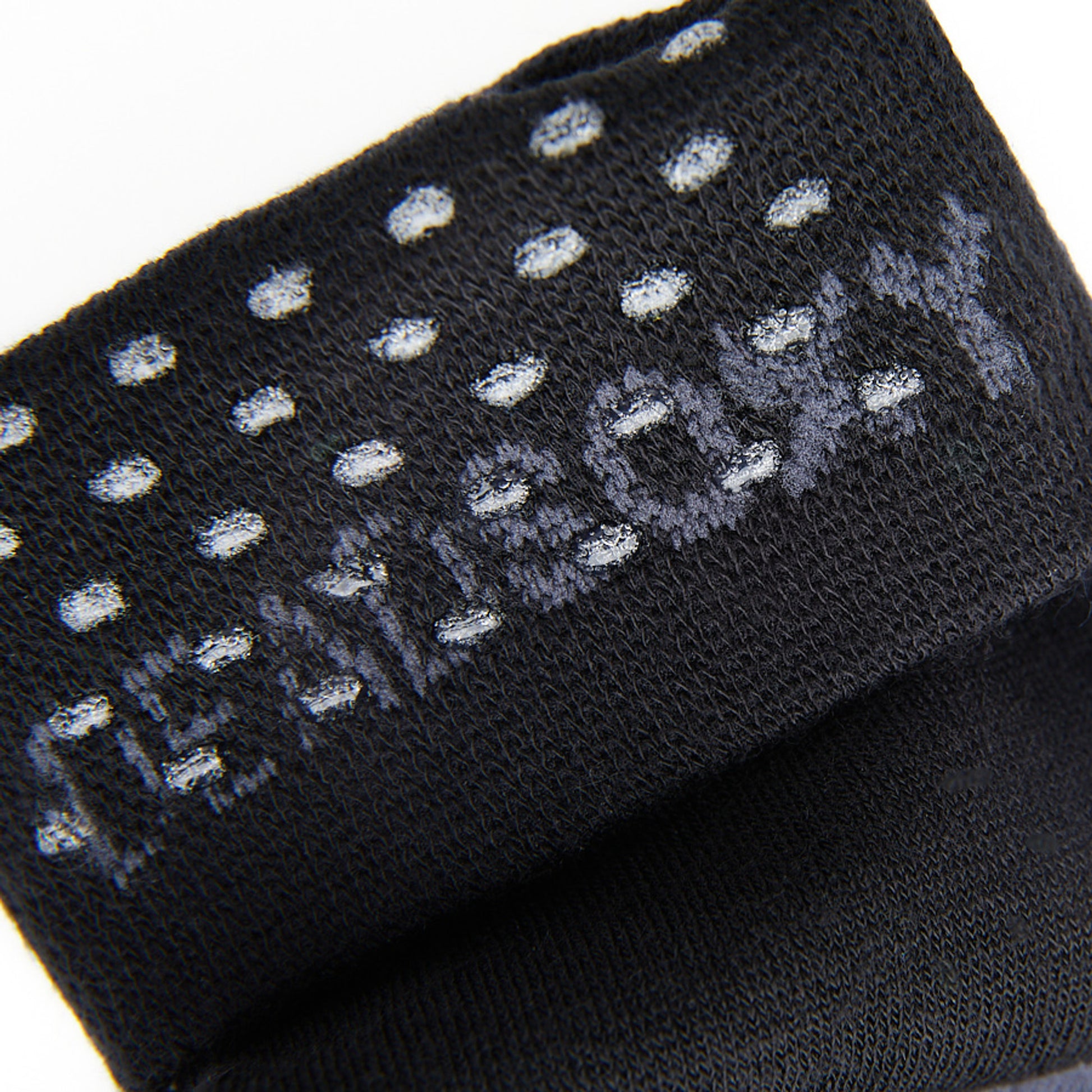 Close up of TrueStay‚Ñ¢ in  the welt of black dress socks with DeadSoxy knit in