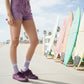 Lilac quarter crew socks styled with surfboard prop.