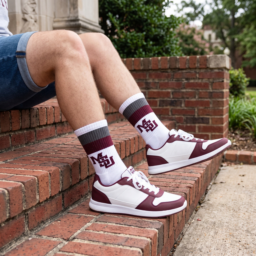 MSU Retro Stripe Casual socks worn seated on campus, showing maroon and gray banding with the interlocking MSU logo on white