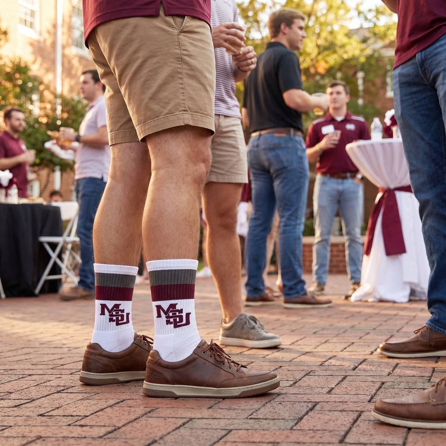 MSU Retro Stripe Casual socks worn standing on campus, second angle, showing maroon and gray banding with the interlocking MSU logo on white