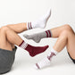 man and woman wearing 4 different maroon, white, and grey casual crew socks.