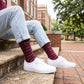 MSU Hail State Dress socks worn seated on campus, showing repeating HAIL STATE text in white and gray on maroon