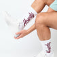 Maroon dress socks with Howdy written in script text in grey and white.