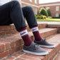 MSU Retro Script Casual socks worn seated on campus, showing the State script on a white band across a maroon crew