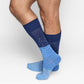 Blue patterned socks worn by a person on a light gray background