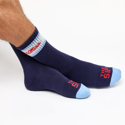 Navy casual crew socks with Ole Miss script on the side of the calf shown on feet crossed.