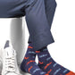Licensed navy blue dress socks with the Ole Miss script logo in red and powder blue blue in repeating pattern shown close up.