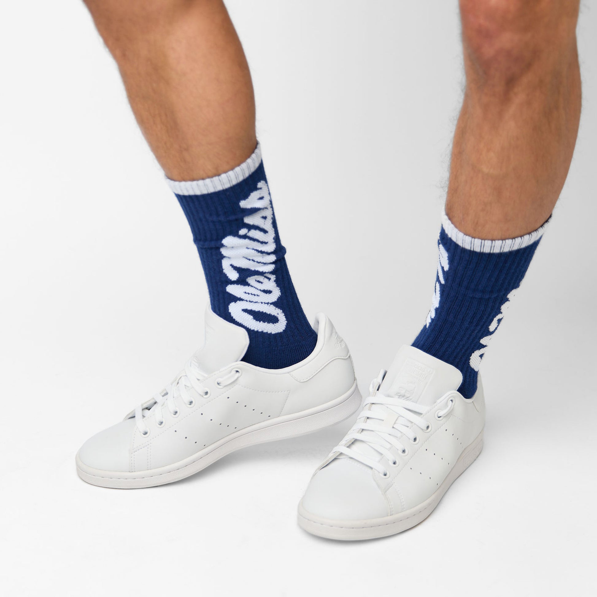 man wearing navy crew socks with Ole Miss written down the leg in white sneakers