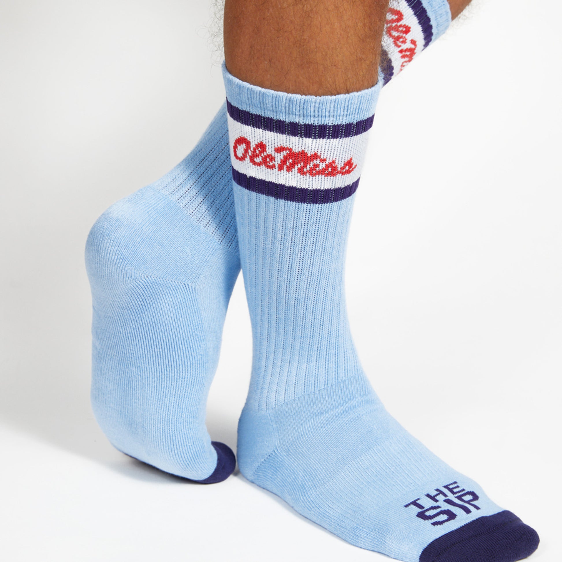 Powder Blue casual crew socks with Ole Miss script on the leg and two retro stripes shown on legs.