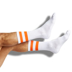 White casual crew socks with orange retro stripes shown on legs