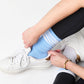 powder blue crew socks with 4 white stripes on leg sitting in white sneaker