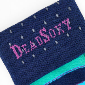 Close-up of DeadSoxy logo on navy TrueStay‚Ñ¢ cuff with silicone dots on Rolly striped sock.