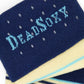 Close-up of DeadSoxy logo on navy TrueStay‚Ñ¢ cuff with silicone grip dots on Samuel striped dress sock.
