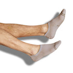 A solid beige cotton no show sock on legs