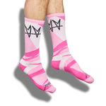 Not.Travis casual collab socks with pink geometric design shown on legs.