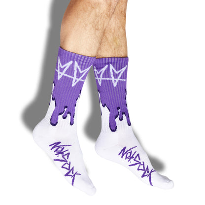 Not.Travis casual collab socks with purple drip shown on legs coming in from the top of the screen.