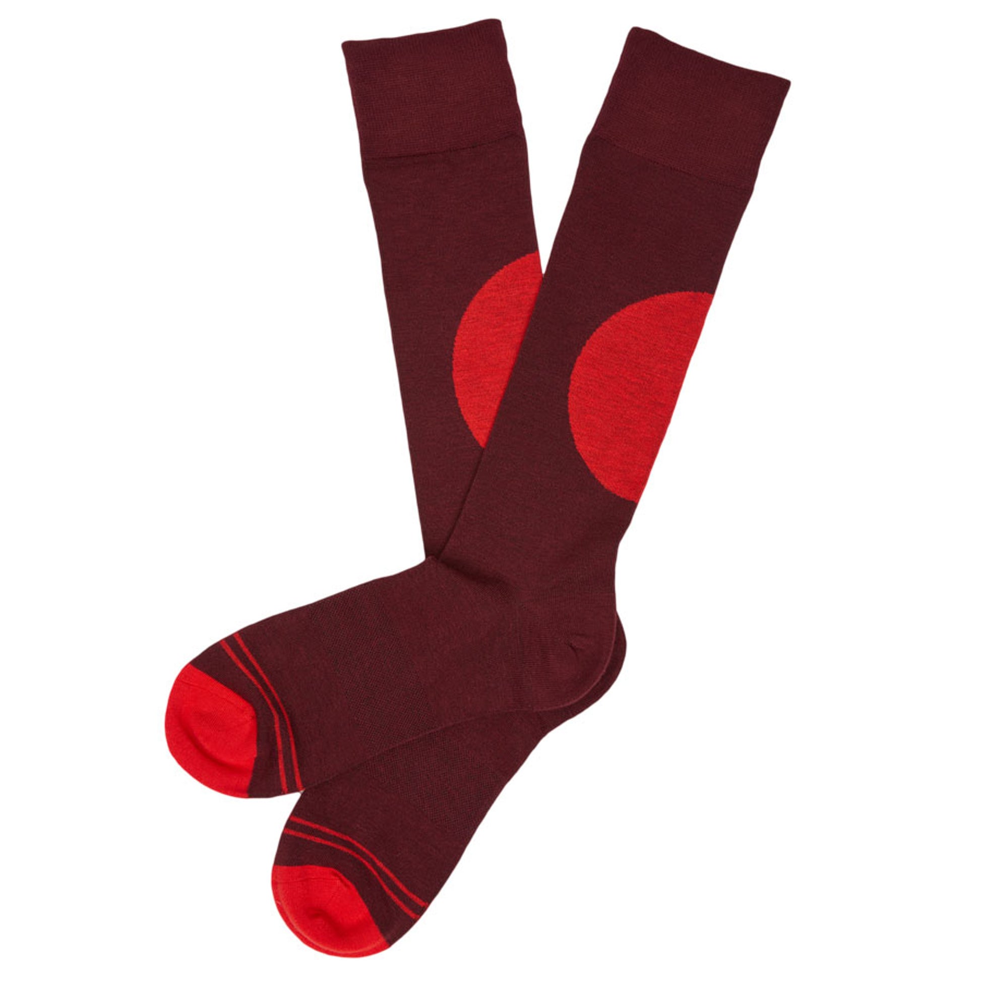 one pair of deep red dress socks with a single alert red big dot off center on the calf laid out flat and crossed at the heel