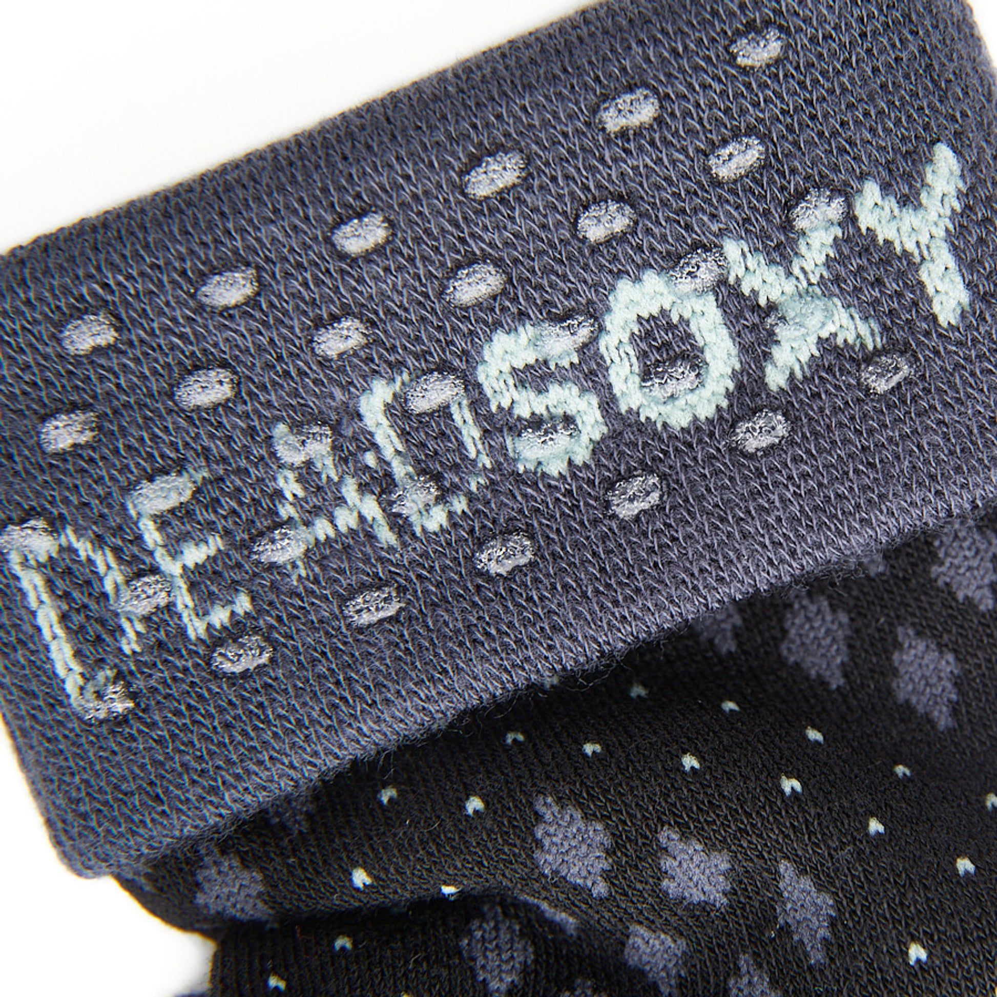Close up of the DeadSoxy TrueStay‚Ñ¢ tech in the grey welt of dress socks.