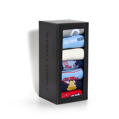 Black box with colorful socks inside, featuring 'Weekly Supply' branding. Weekly Sply Hemmingway Ole Miss 7-Pack boxed set displayed upright with all socks stacked vertically.