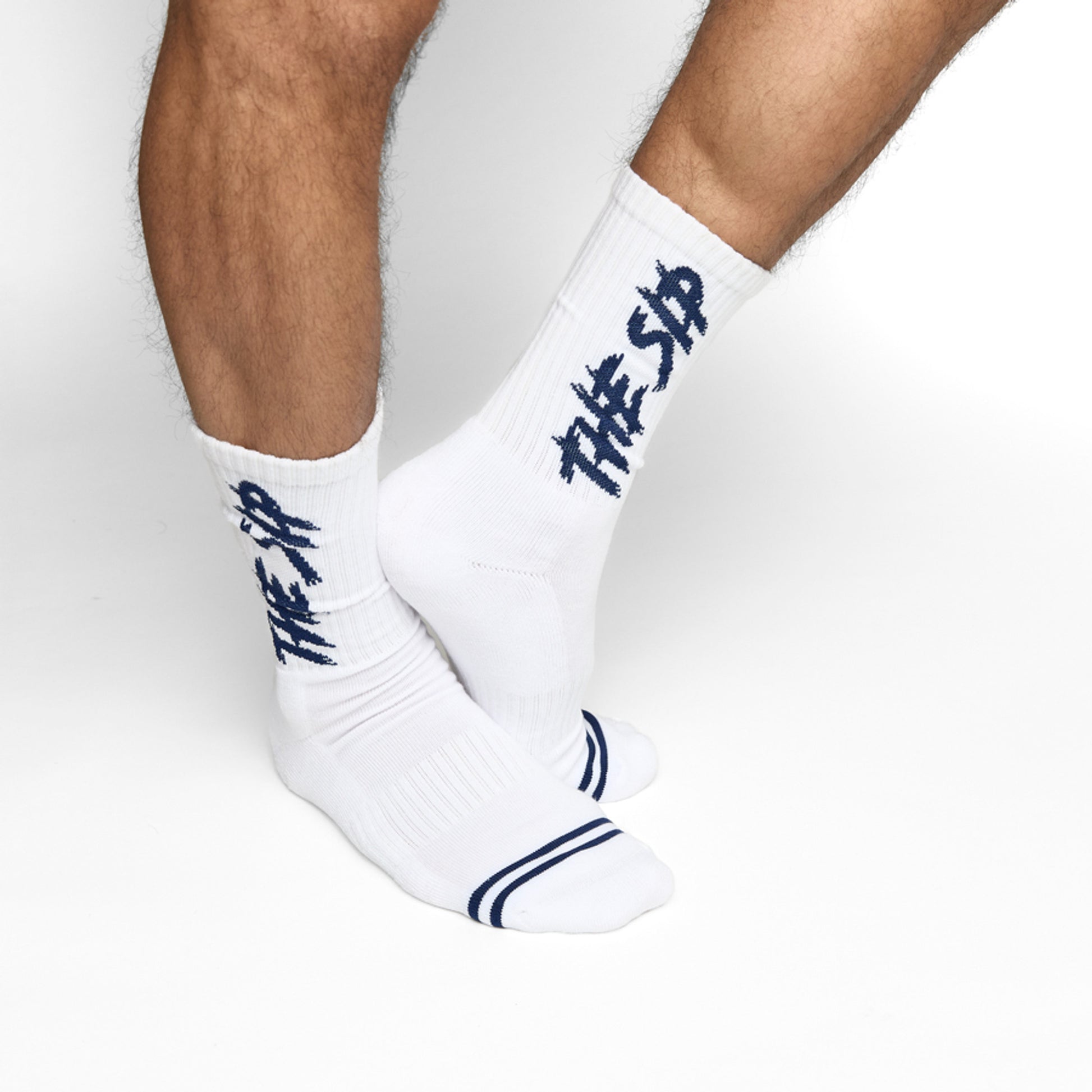 White casual crew socks with THE SIP in navy written down the shown on male model