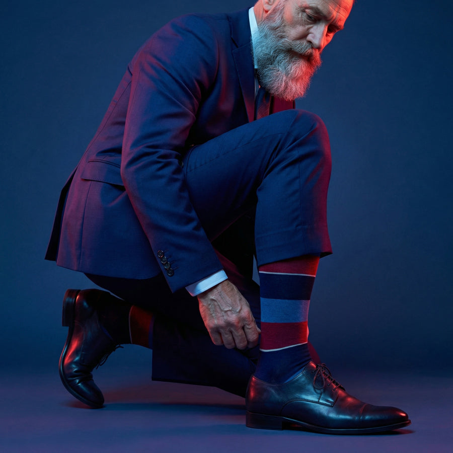 Tomas navy blue and red block stripe dress socks under neon lighting